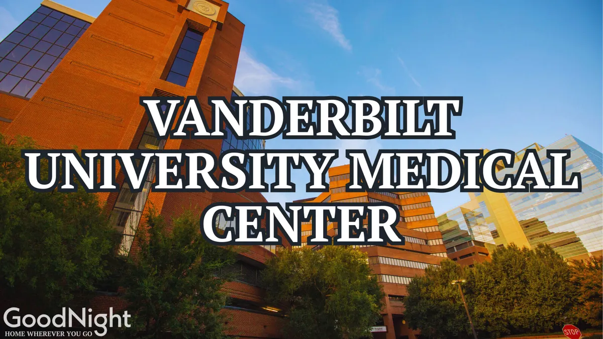 A dynamic shot of the Vanderbilt University Medical Center building with lush greenery in the foreground and a bright blue sky above. The modern architecture of the hospital is prominent, surrounded by an inviting, well-maintained landscape.