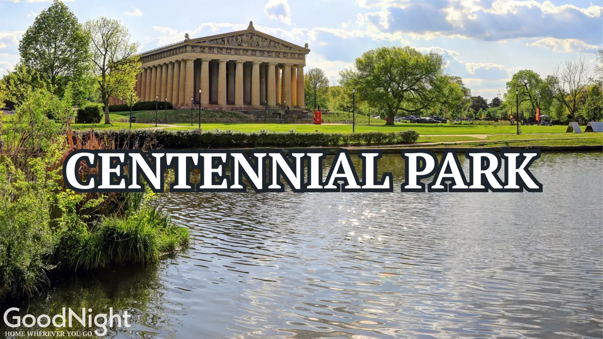 A tranquil exterior view of the Parthenon-like structure at Centennial Park, with calm water in the foreground and lush greenery surrounding the area. The scene invites leisurely walks, relaxation, and exploration of local art and history.