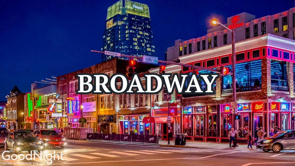A vibrant Nashville street scene at night featuring colorful neon signs, illuminated buildings, and people strolling along the bustling sidewalk. The energy of the nightlife is palpable, with diners, live music venues, and an array of shops lining the street.