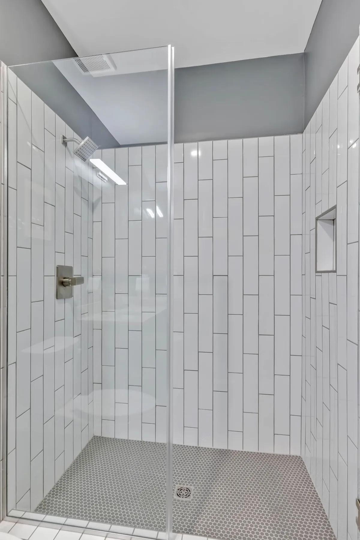 A bright, modern bathroom with a glass-enclosed walk-in shower, sleek fixtures, and chic tilework. The space feels refreshing, clean, and luxurious, perfect for unwinding after a busy day.